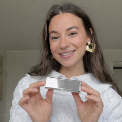 Woman holding a silver rectangular pillbox with for engraving 