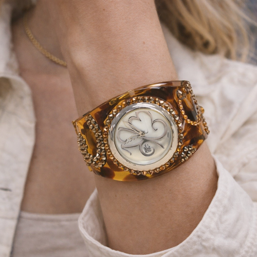 Close-up of a person wearing a crystal decorative wristwatch with a blurred background