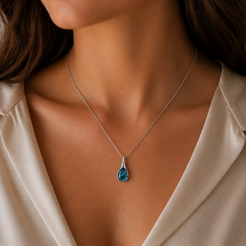 Close-up of a woman wearing a crystal necklace with a blue pendant.