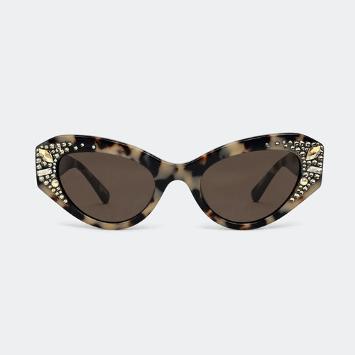 Cats-eye sunglasses with a tortoiseshell pattern, gold rhinestone embellishments on the outer corners, and dark brown lenses, shown against a light gray background.