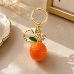 Keychain with an orange and gold design on a light surface